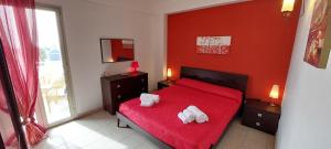 a bedroom with a red bed with two towels on it at Belvedere Casuzze in Santa Croce Camerina