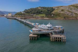 een cruiseschip aangemeerd op een pier in het water bij Carmen Sylva Llandudno Beach ground floor Flat in Llandudno