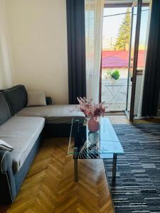 sala de estar con sofá y mesa de cristal en Cozy apartment near city center, en Bucarest
