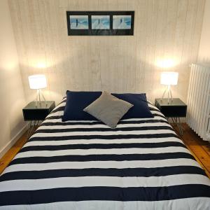 ein Schlafzimmer mit einem großen Bett mit zwei Lampen in der Unterkunft Maison vue mer à 200 M de la plage Corn Ar Gazel in Saint-Pabu