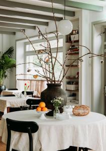 a table with a vase with branches and oranges on it at Bergen1928 in Bergen