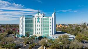 a large white building with a clock on it at Hotel Landy Orlando Universal Blvd, a Tribute Portfolio Hotel in Orlando