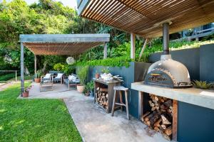 einen Hinterhof mit einem Grill im Freien und einer Terrasse in der Unterkunft The Beach Bungalow in Durban