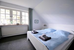 1 dormitorio con 1 cama con toallas en Heidsandschier Hausteil Nordlys, en Witsum