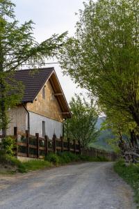 a house on a road next to a fence at Ograda Magura village in Măgura