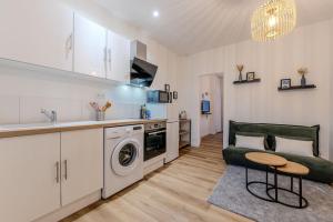 a kitchen and living room with a washing machine and a couch at Joli T2- cocooning - wifi fibre - lave-linge in Grenoble +27 photos