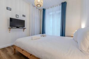 a bedroom with a bed and a flat screen tv at Joli T2- cocooning - wifi fibre - lave-linge in Grenoble