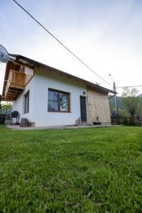 ein Haus mit Rasen davor in der Unterkunft Ograda Magura village in Măgura