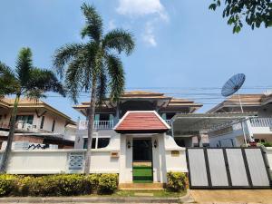 a house with a palm tree in front of it at 长住优惠房-芭提雅市中心高端4间卧室泳池别墅，好莱坞，21航站楼 in Pattaya Central