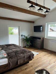 een slaapkamer met een bed en een flatscreen-tv bij Cityapartments Reutte in Reutte