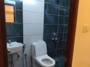 a bathroom with a toilet and a sink at OGinn in Chennai