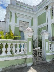 um edifício verde e branco com um portão em quintal293 no Recife