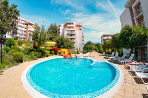 a swimming pool with a slide and a playground at Crown Fort Club in Sveti Vlas