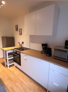 uma cozinha com armários brancos e uma bancada em Zentral gelegene Appartement. em Gelsenkirchen