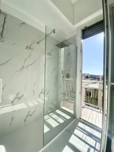a bathroom with a shower with white marble walls at Amazing 3 Rooms Bocconi Apartment - 1.6 km Duomo in Milan
