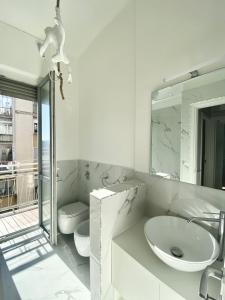 a white bathroom with a sink and a mirror at Amazing 3 Rooms Bocconi Apartment - 1.6 km Duomo in Milan