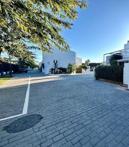 una calle adoquinada frente a un edificio en Villa Bosque Novo Sancti petri Grupo AC Gestión, en Chiclana de la Frontera