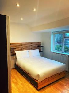 sypialnia z dużym łóżkiem z drewnianym zagłówkiem w obiekcie 133C HiBrid Home w Oksfordzie