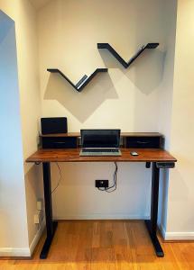 een bureau met een laptop en een grafiek op de muur bij 133C HiBrid Home in Oxford