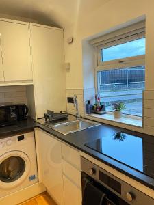 a kitchen with a sink and a washing machine at 133C HiBrid Home in Oxford