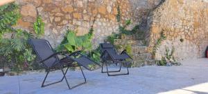 two black chairs sitting next to a stone wall at Villa Verde Pet-friendly in Córdoba