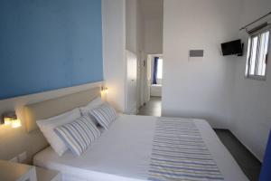 a bedroom with a white bed with two pillows at Blue Senses Apartments in Sarti