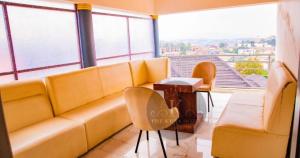 a living room with a yellow couch and a table at THE KEZA HOTEL near Kigali international airport. in Kigali