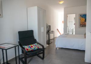 a bedroom with a bed and a chair and a chair sidx sidx sidx at Apartamentos Bellavista Gomera in Playa de Santiago