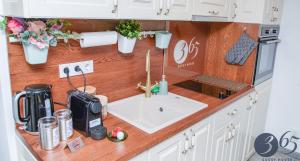 a kitchen counter with a sink in a kitchen at 365 Guest House in Hunedoara