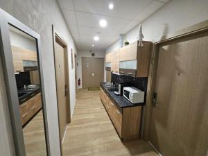 a kitchen with a sink and a microwave at Kambarys su balkonu ir didele lova Kauno centre #6 in Kaunas