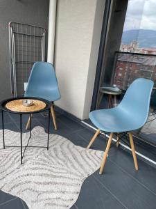 una silla azul y una mesa en el balcón en Urban LEKS apartment, en Skopje