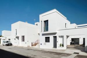 a white house with a car parked in front of it at Adosado Marol solo familias in Conil de la Frontera