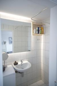a white bathroom with a sink and a mirror at Central aesthetic studio with panoramic views in Patra