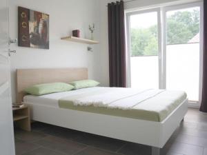 un letto in una camera con una grande finestra di Luxury holiday house "Schleibrise" 