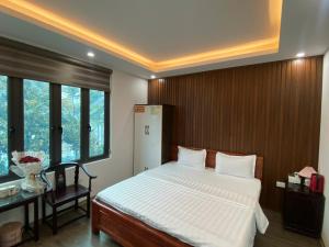 1 dormitorio con 1 cama, escritorio y ventanas en Joy Nibi Guest House en Ninh Binh