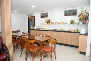 a restaurant with tables and chairs and a counter at Trip Hotel Lauro de Freitas in Lauro de Freitas