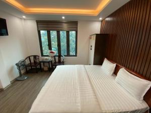 een groot wit bed in een kamer met een raam bij Joy Nibi Guest House in Ninh Binh