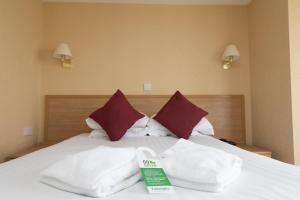uma cama com toalhas brancas em cima em George IV Hotel em Criccieth