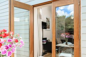 a sliding glass door with flowers in a room at No 10 The Towans in St Merryn