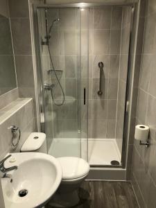 a bathroom with a shower and a toilet and a sink at George IV Hotel in Criccieth