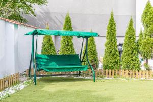 a green swing in a yard with trees at Neighboring 3 Apts.- Ideal for Families & Friends in Vienna