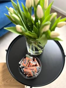 uma mesa preta com um vaso com flores em The blue VIEcation apartment em Viena