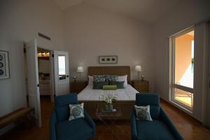 a bedroom with a bed and two blue chairs at Luxury 3 Bedroom at El Conquistador in Fajardo