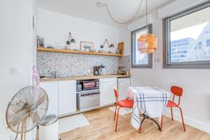 cocina con mesa, sillas y ventilador en Studio Charles, en La Grande-Motte