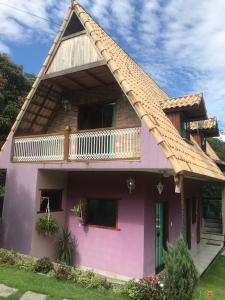 una casa rosa con tetto di gamberetti di Chalé do Robinho a Macaé