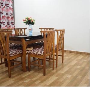 een eettafel met stoelen en een vaas met bloemen bij zoz mg2 in Oud Goa