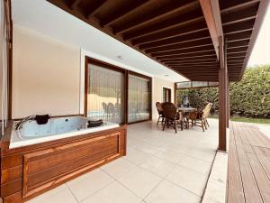 un patio con bañera, mesa y sillas en Riyan Garden Villas, en Sapanca
