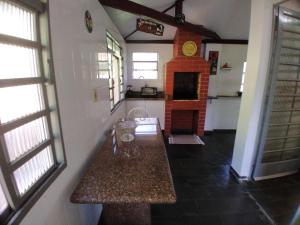 a kitchen with a table and a fireplace in a room at Casa de Campo Circuito das Aguas in Amparo