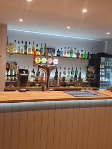 a bar with a counter with bottles of alcohol at Selborne Hotel in Dunoon