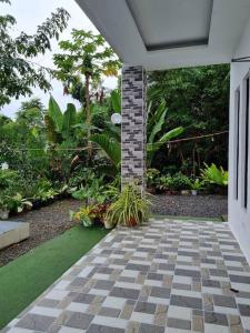 een veranda met een bakstenen pilaar en planten in een tuin bij Home in BoholPhilippinesVilla Santorino in Lila